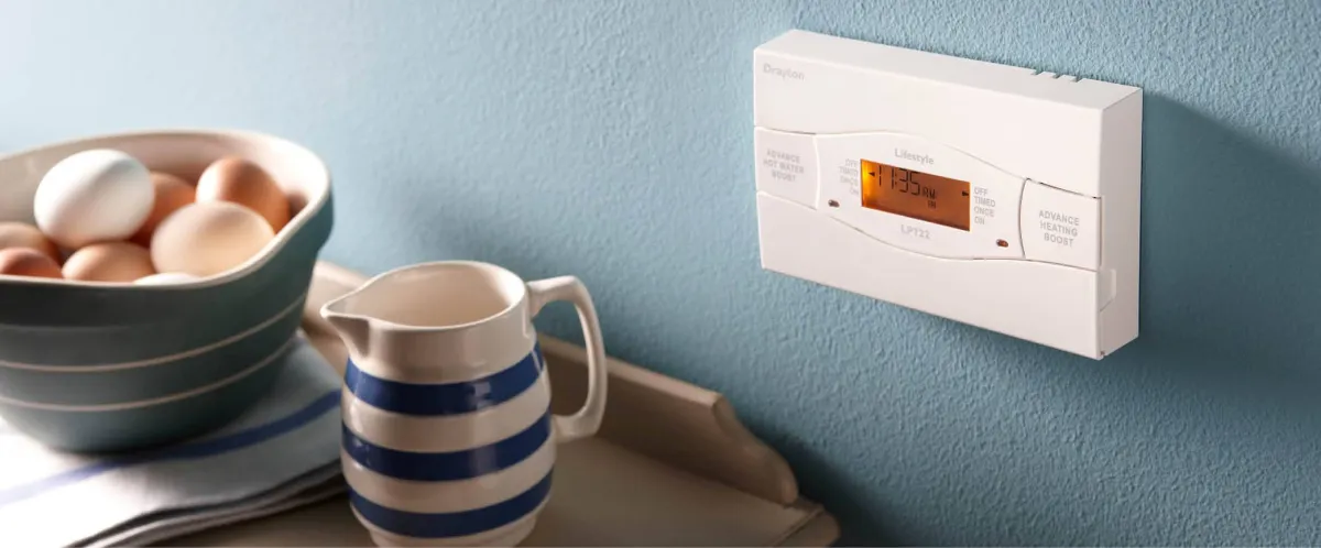 Time controller on a wall next to a tray with eggs in a bowl