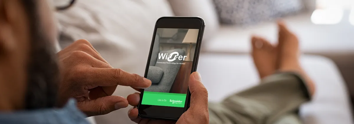 Person lying on couch using Wiser app on mobile device