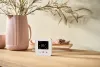 Wiser room thermostat on a table with a plant - Benefits of smart heating controls for renters