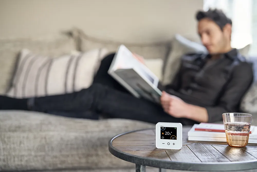 Man relaxes while Wiser's smart thermostat ensure a comfortable temperature in Comfort Mode